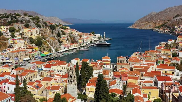 View on Symi (Simi) island harbor port, classical ship yachts, houses on island hills, Aegean Sea bay. Greece islands holidays vacation travel tours from Rhodos island. Symi, Greece,  Dodecanese.