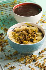 Açai bowl, with granola and banana, on a glass bottom and cereals around