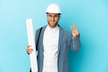 Young architect man with helmet and holding blueprints over isolated background happy and counting...