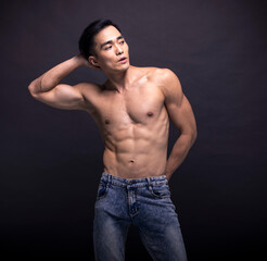 Fototapeta na wymiar Muscular bodybuilder Asian man doing posing over black background