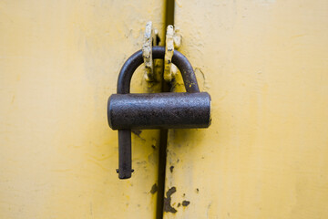 Old vintage iron lock on   yellow door
