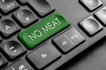 dunkelgrüne "No Meat" Taste auf einer dunklen Tastatur	