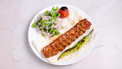 Adana kebab with herbs and vegetables