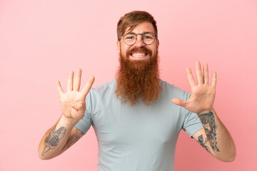 Young reddish caucasian man isolated on pink background counting nine with fingers