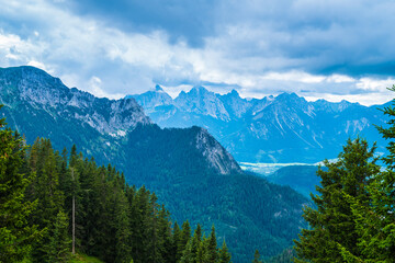Fototapeta na wymiar Germany, Tegelberg mountain peak view in bavarian allgaeu nature landscape into valley of fuessen with cloudy sky