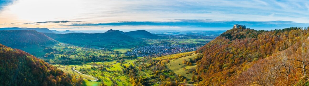 Germany, XXL panorama hohenneufen castle swabian alb on top of a mountain at neuffen village  houses in autumn season at sunset