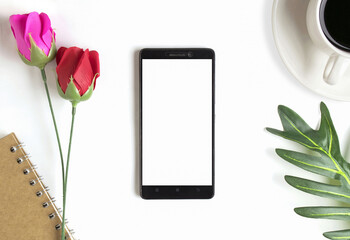 Office Desk table work space with Smartphone,Leaves, red roses, pink roses, coffee cups, notebooks on white background.for workplace and valentines day top view .