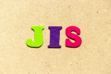 Color cloth alphabet letter in word JIS (abbreviation of Just in sequence) on wood background