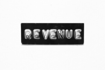 Black color banner that have embossed letter with word revenue on white paper background