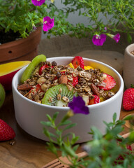 Tropical Salad of Fruits with mango, strawberry, kiwi, melon and granola