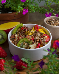 Tropical Salad of Fruits with mango, strawberry, kiwi, melon and granola