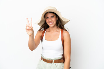 Obraz na płótnie Canvas Young caucasian woman wearing a Pamela in summer holidays isolated on white background smiling and showing victory sign