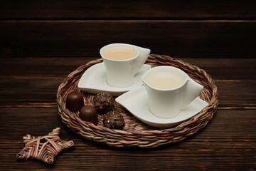 A cup of tea on a wicker tray. Chocolates.