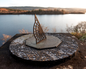 Vintage sundial overlooking Loch Awe, Scotland. Grounds of a local gothic church / kirk. - obrazy, fototapety, plakaty