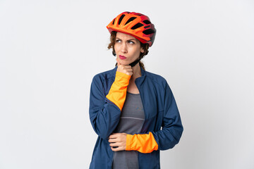 Young cyclist woman isolated on white background having doubts and thinking