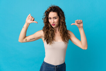 Young caucasian woman isolated on blue background proud and self-satisfied