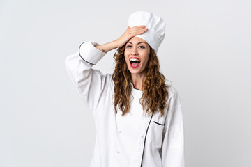 Young chef woman isolated on white background doing surprise gesture while looking to the side