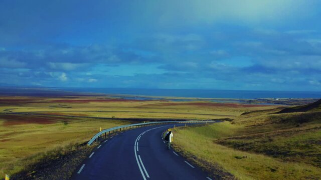 Panoramic view of man in white jacket walking on the road in steppe, Iceland 