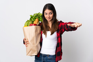 Young caucasian with vegetables isolated on white background giving a thumbs up gesture