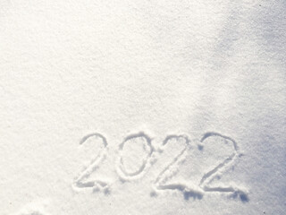 The inscription on the snow New 2022. Christmas Eve, winter day with snowfall. flying snowflakes. there are shiny winter snowdrifts on the ground, New Year's mood outside