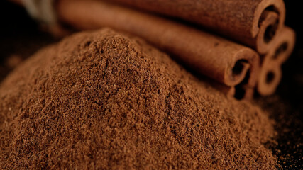 Cinnamon sticks and cinnamon powder isolated on black background