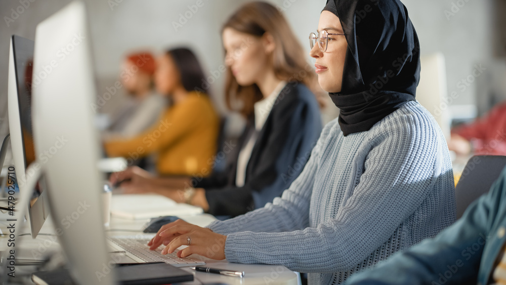 Fototapete curious female muslim student wearing a hijab, studying in modern university with diverse multiethni