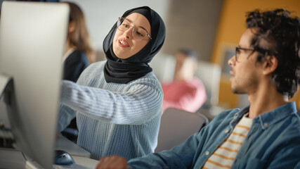Female Muslim Student Wearing Hijab, Studying in Modern University with Diverse Multiethnic...