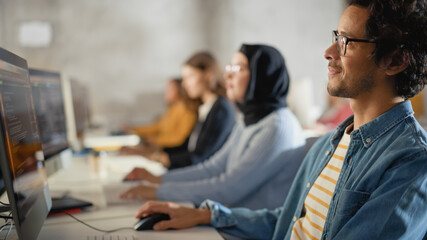 Teacher Giving Lesson to Diverse Multiethnic Group of Female and Male Students in College Room, Learning New Academic Skills on a Computer. Lecturer Shares Knowledge with Smart Young Scholars.
