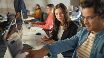 Diverse Multiethnic Group of Female and Male Students Sitting in College Room, Collaborating on...