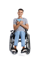 Young man in wheelchair and with book on white background