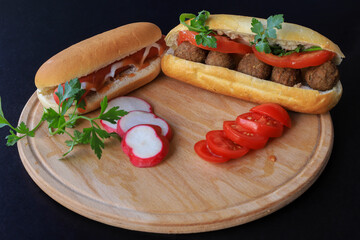 Hot dog - grilled sausage in bun with gravy isolated on black background.Swedish meatballs in breadcrumbs