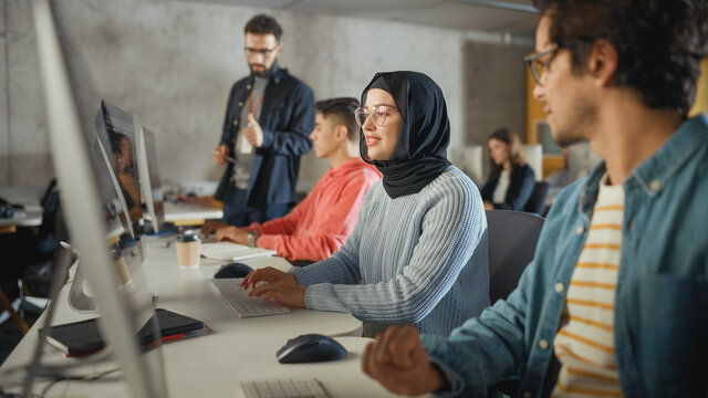 Female Muslim Student Wearing Hijab, Studying in Modern University with Diverse Multiethnic Classmates. She Asks Scholar a Question in College Room. Lecturer Shares Knowledge with Smart Scholars.