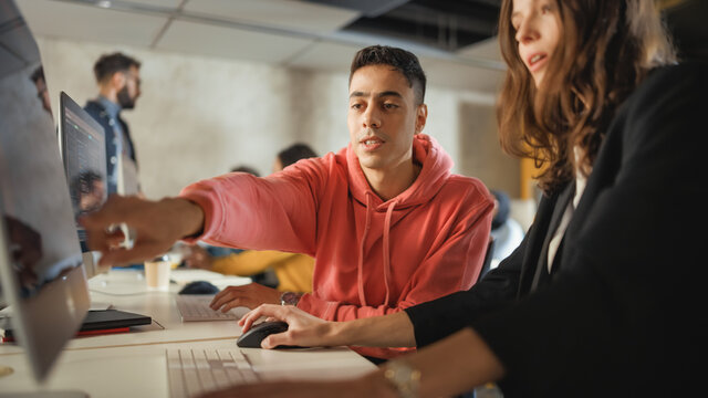 Diverse Multiethnic Group Of Female And Male Students Sitting In College Room, Collaborating On School Projects On A Computer. Young Scholars Study, Talk, Apply Academic Skills And Knowledge In Class.