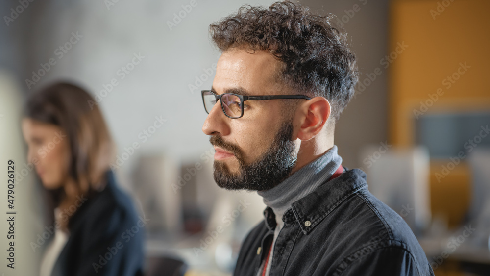 Poster portrait of a handsome concentrated smart male student, studying in modern university. he wears glas
