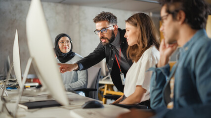 Lecturer Helps Scholar with Project, Advising on Their Work. Teacher Giving Lesson to Diverse Multiethnic Group of Female and Male Students in College Room, Teaching New Academic Skills on a Computer.