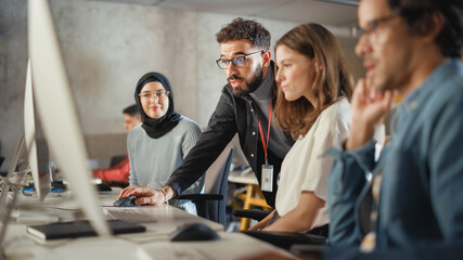 Lecturer Helps Scholar with Project, Advising on Their Work. Teacher Giving Lesson to Diverse Multiethnic Group of Female and Male Students in College Room, Teaching New Academic Skills on a Computer.