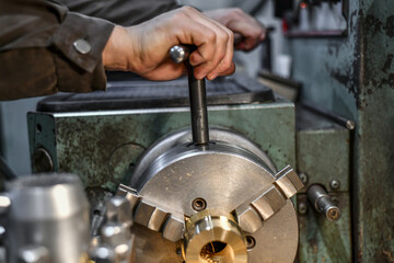 The work turner clamps the bronze parts in the jaws of the lathe chuck.