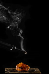 wax candle with burning wick and smoke, isolated on a black background