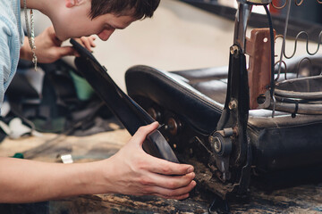 Repair of the old car seat. Car mechanic's hands is using tools.