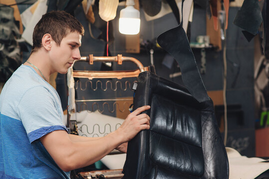 Repair Of The Old Car Seat. Car Mechanic's Hands Is Using Tools.