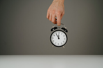 Hand holding black alarm clock