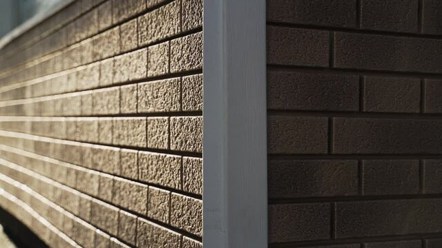 Corner of a brick house finished with plastic siding
