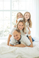 Portrait of smiling family at home. Mother, father and two kids indoor