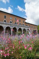 Obraz premium Pisa, Italy, September 2015, view of the Pisa train station from a flower bed with pink flowers