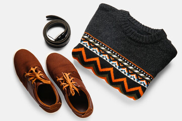Dark male sweater, shoes and belt on white background