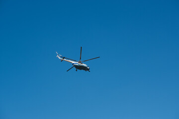Modern helicopter flying in the blue sky.Flying transport helicopter.The aircraft, the big helicopter at competitions makes flight at low height.