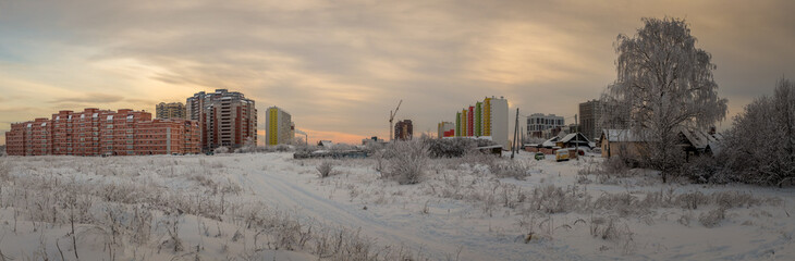 panorama of a large construction site illuminated by the setting sun on a frosty winter evening