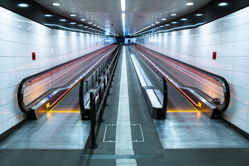 Glasgow Subway - Modern moving stairway escalator within a brightly illuminated modern underground...