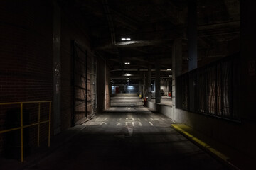 Underground parking scene - Gloomy industrial scene - modern painted handrails - old concrete and brick structure - vehicle loading bay