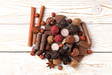 Concept of sweets with chocolate candies on white wooden background